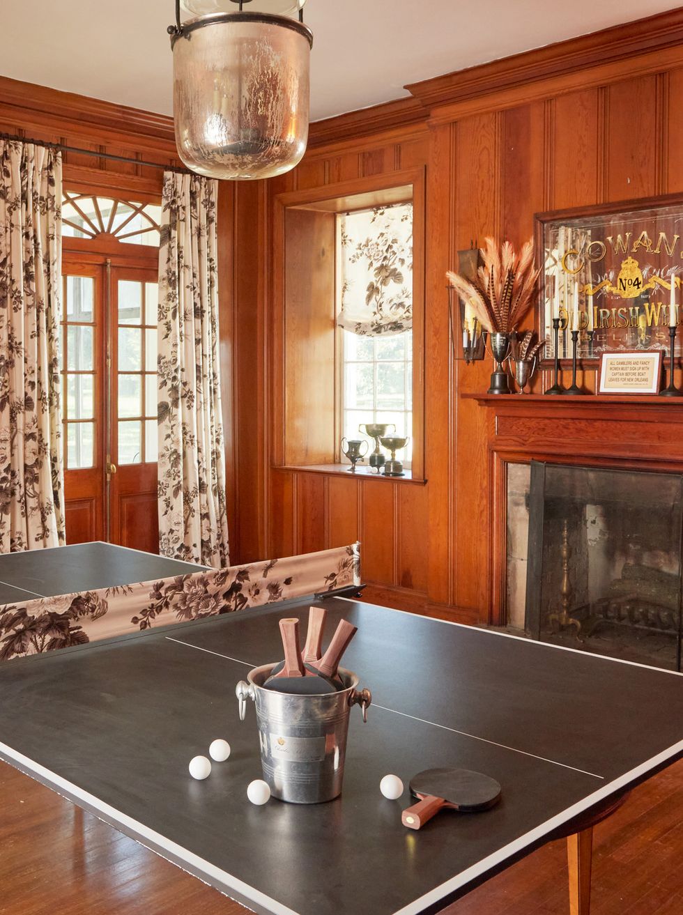 ping pong table with floral fabric net in wood paneled room