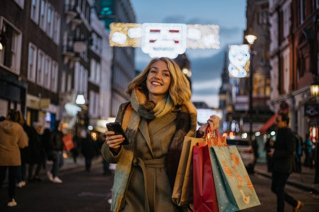 young woman shopping and carrying bags down the street