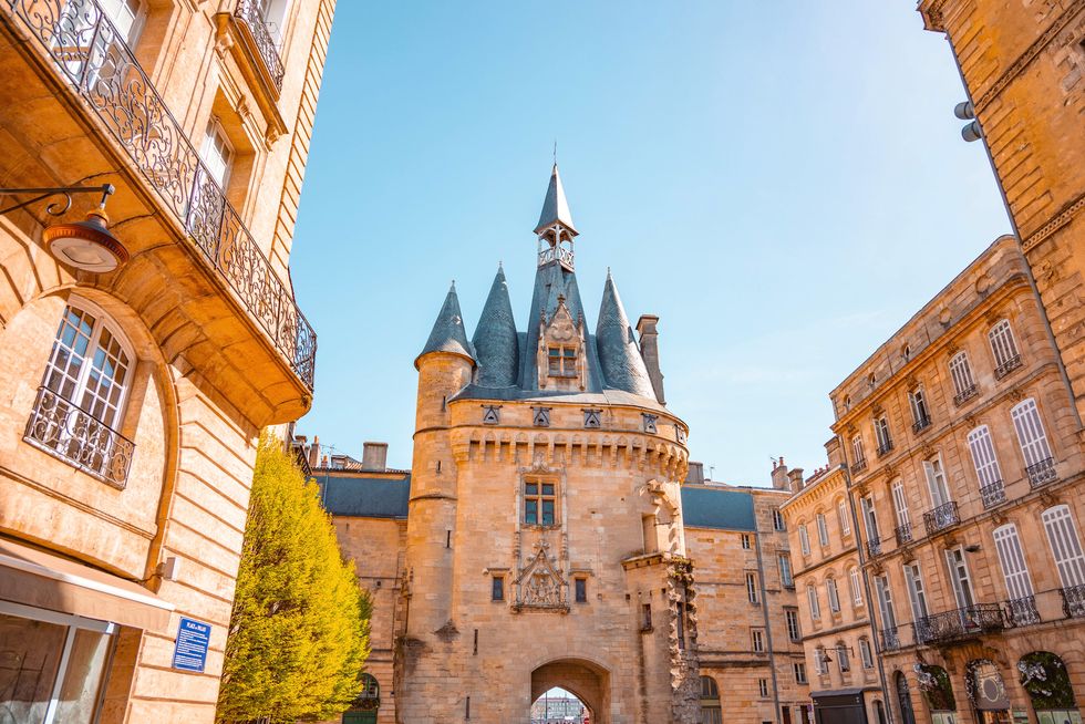 the architecture of the bordeaux city with golden light and the cailhau gate in france