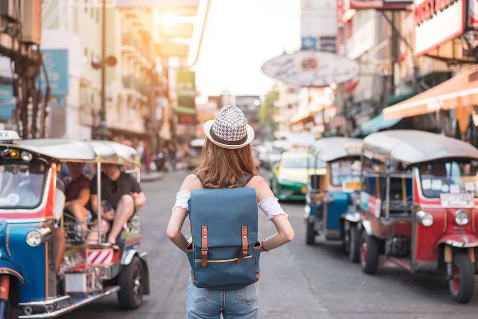 giovane donna di spalle che cammina per le vie di bangkok, thailandia