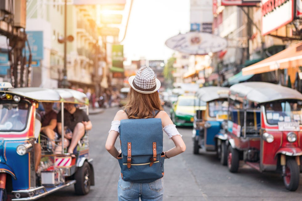 giovane donna di spalle che cammina per le vie di bangkok, thailandia