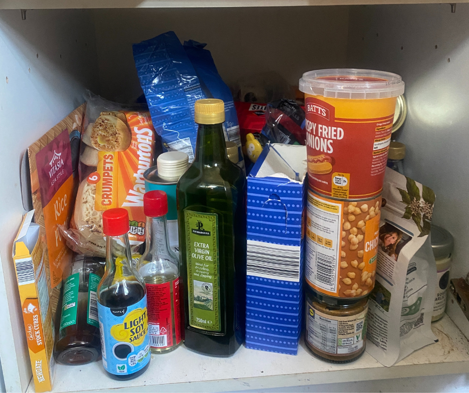 a cluttered pantry shelf containing various food items and condiments