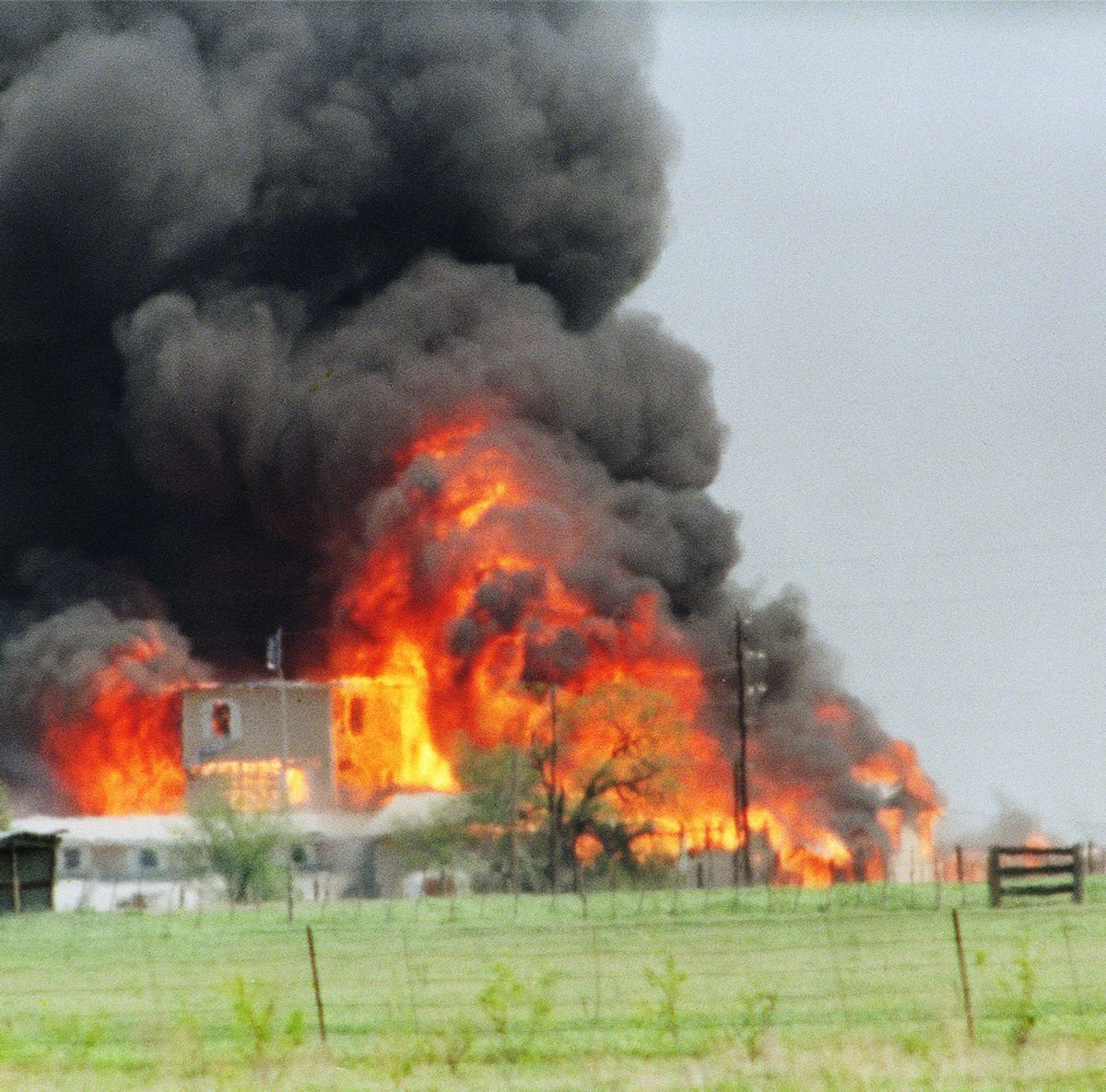 flames erupting from a compound, with smoke billowing into the air