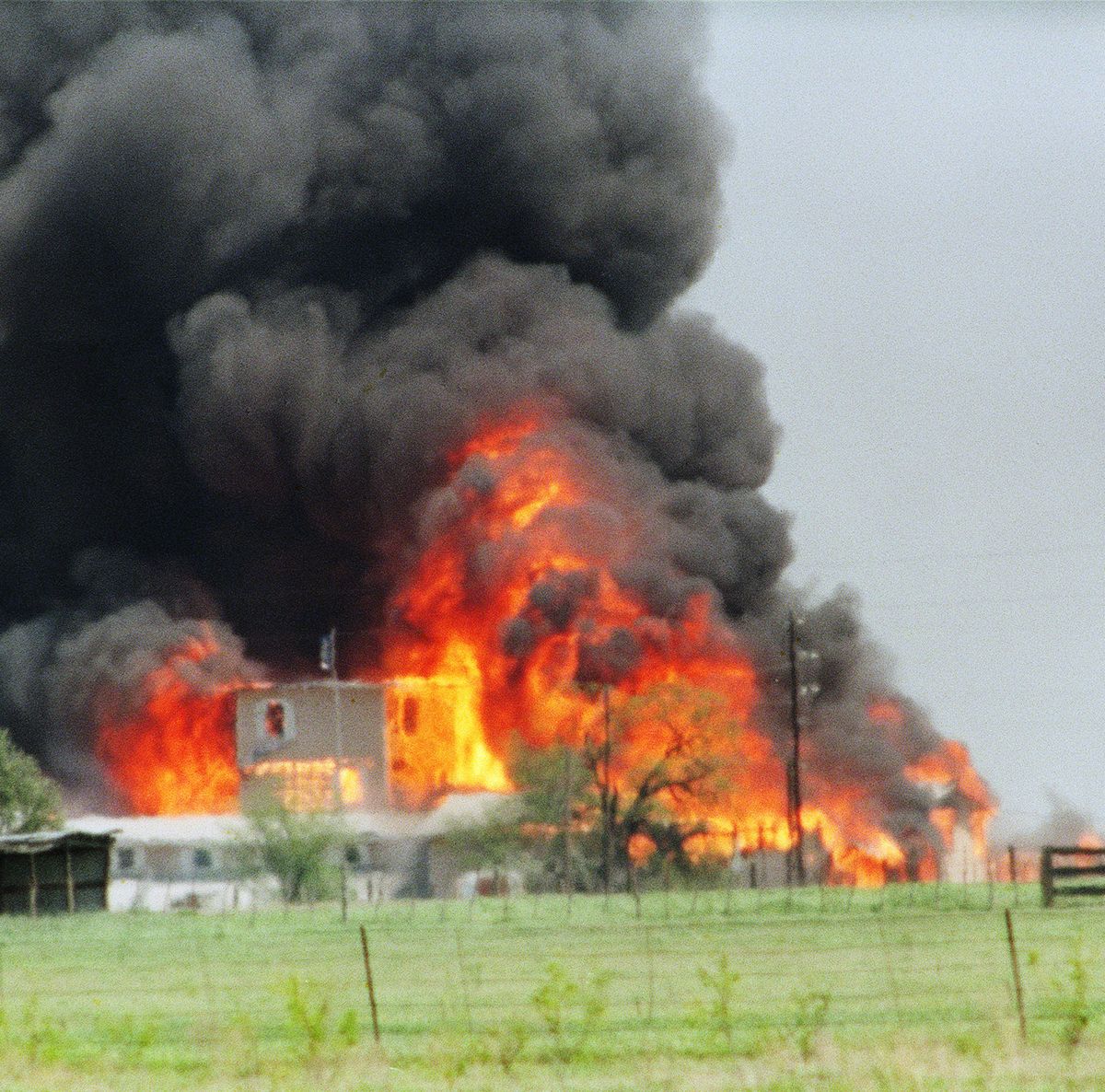 flames erupting from a compound, with smoke billowing into the air