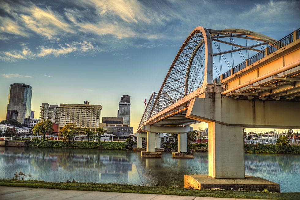 the broadway street bridge spanning over the arkansas river, in downtown little rock, arkansas at sunrise.
