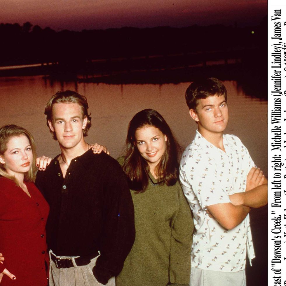 michelle williams, james van der beek, katie holmes, and joshua jackson stand next to each other for a photo with a body of water and a sunset behind them