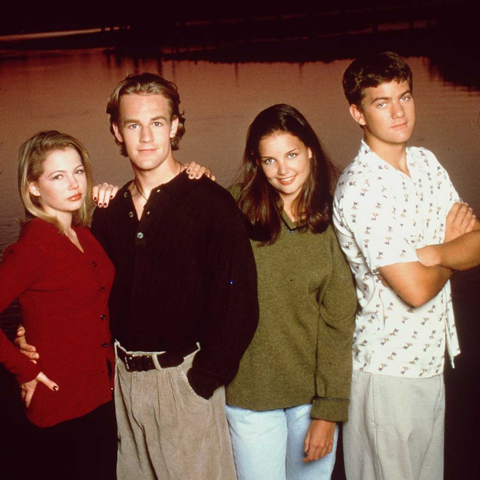 michelle williams, james van der beek, katie holmes, and joshua jackson stand next to each other for a photo with a body of water and a sunset behind them