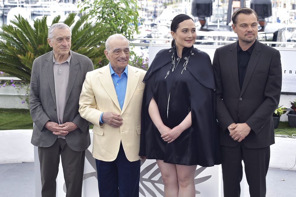 robert de niro, martin scorsese, lily gladstone, and leonardo dicaprio standing side by side and posing for photos at the cannes film festival