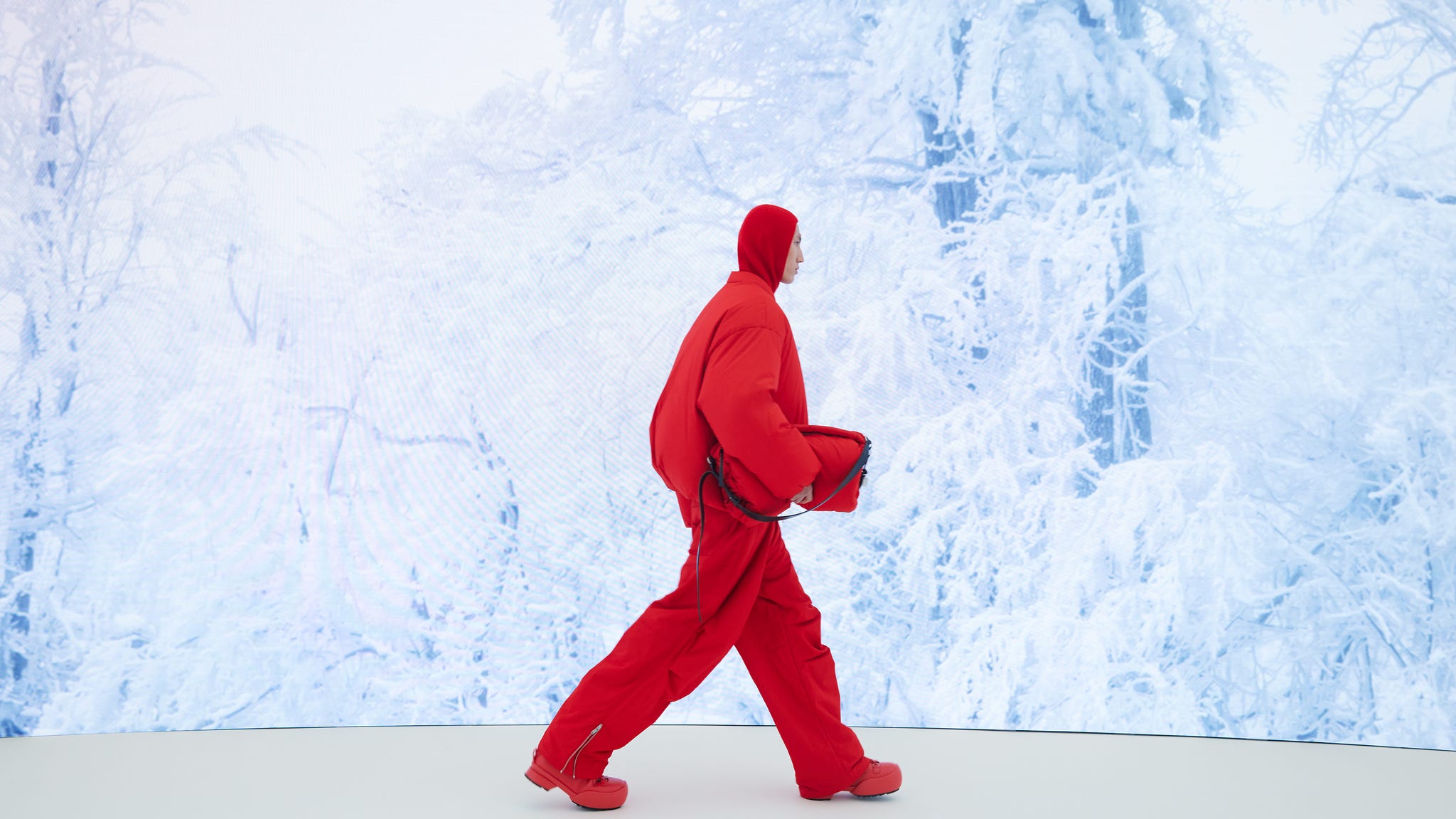 a model in red walking down a runway