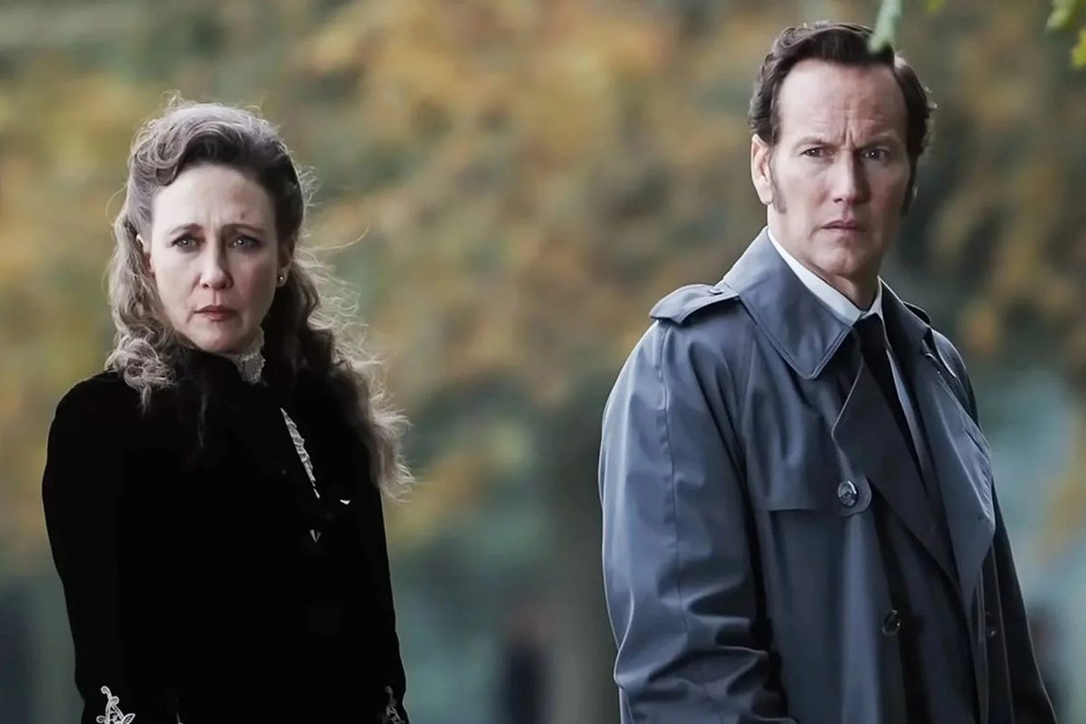 vera farmiga and patrick wilson have severe, stern expressions on their faces as lorraine and ed warren in a scene from the conjuring last rites