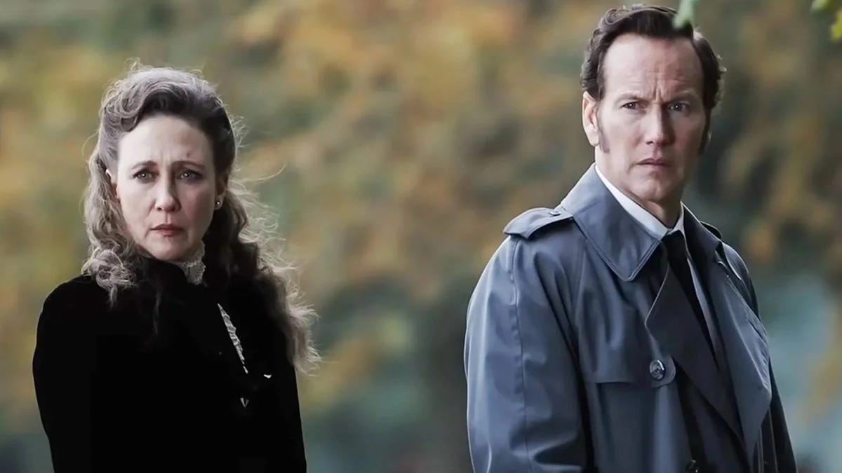 How to Watch All 'The Conjuring' Movies in Order vera farmiga and patrick wilson have severe, stern expressions on their faces as lorraine and ed warren in a scene from the conjuring last rites