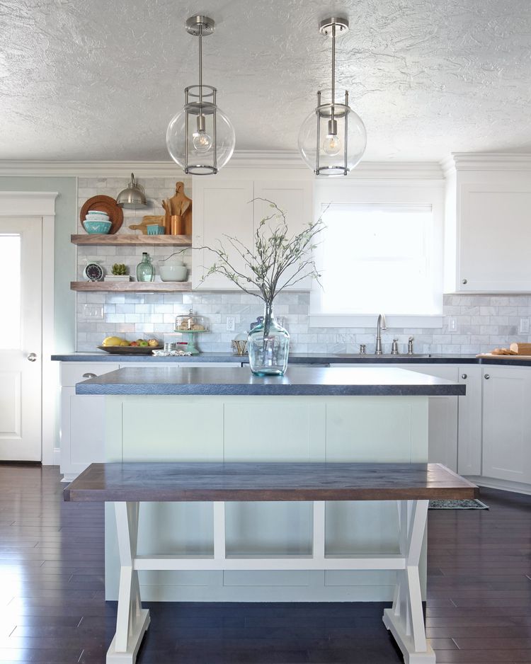 kitchen island idea like dark counter top and a vase with stemmy greenery on it