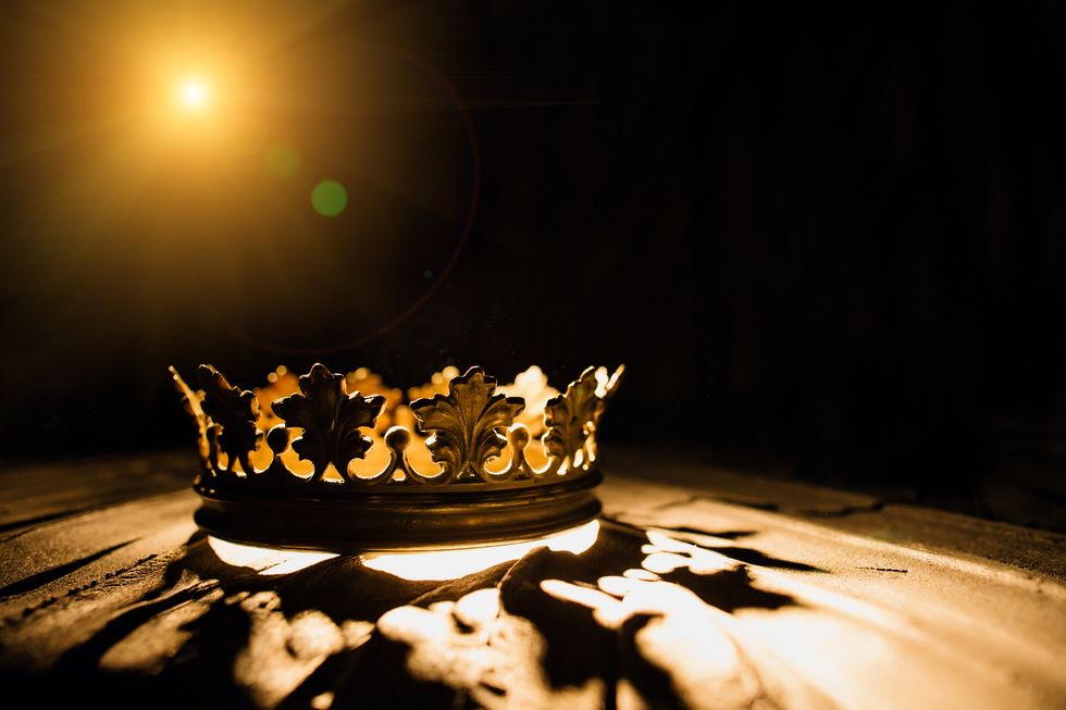 the crown on a black background is illuminated by a golden beam low key image of a beautiful queen royal crown vintage is filtered fantasy of the medieval period battle for the throne