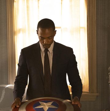 anthony mackie as falcon looking down at the vibranium captain america shield, the falcon and the winter soldier