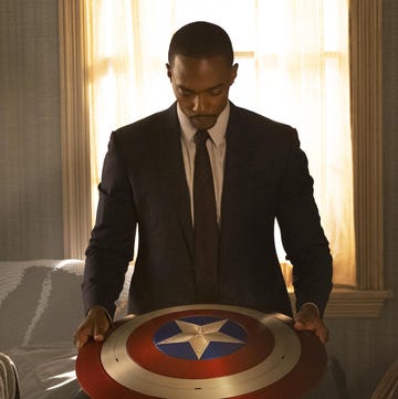 anthony mackie as falcon looking down at the vibranium captain america shield, the falcon and the winter soldier