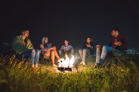 the five people rest near the bonfire evening night time