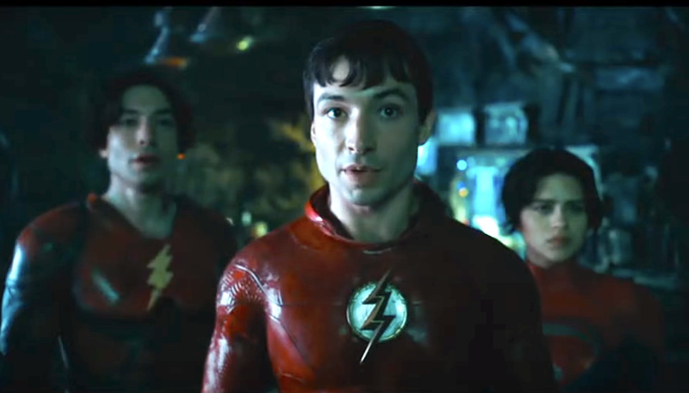 ezra miller vistiendo un disfraz de superhéroe rojo con el logo de un rayo en el flash