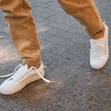 man met witte sneakers aan