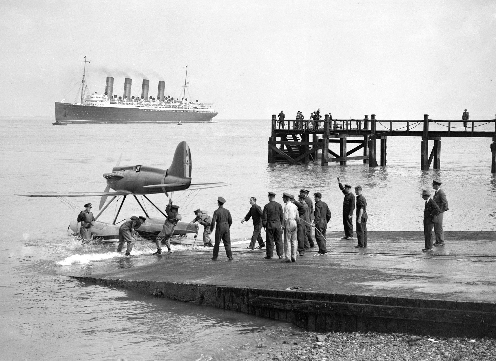 the gloster napier powered supermarine s6 being launched at cowes for the 1929 schneider trophy, with the mauretania in