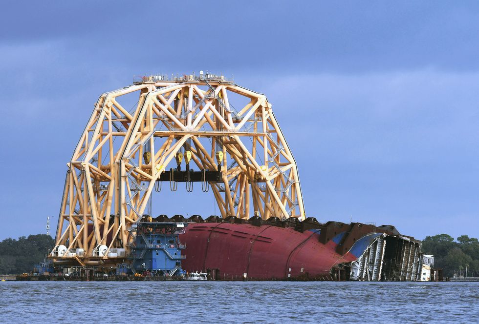 the golden ray cargo ship lies on its side in the water
