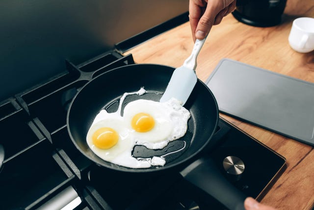 the guy fries fried eggs in a frying pan fried eggs modern cuisine non stick frying pan man's hands