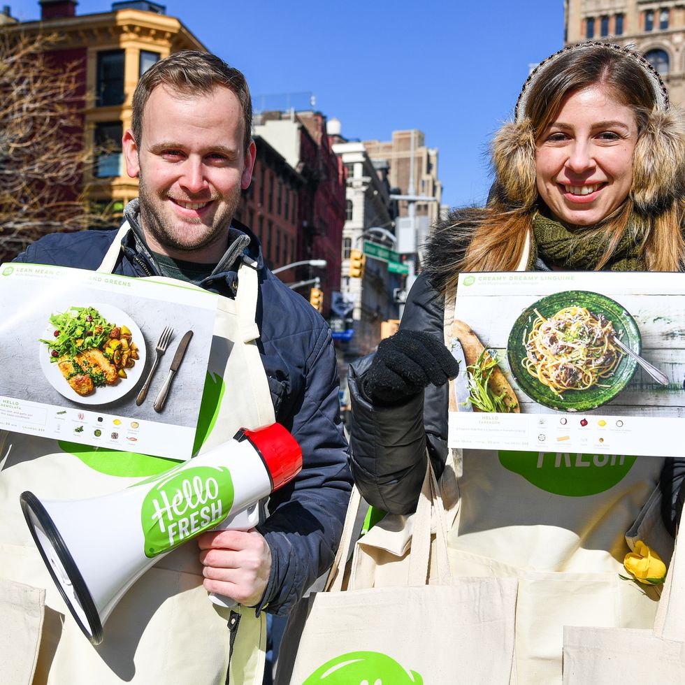 hellofresh, best subscription boxes for teens, a man and a woman holding up hello fresh signs in the day time