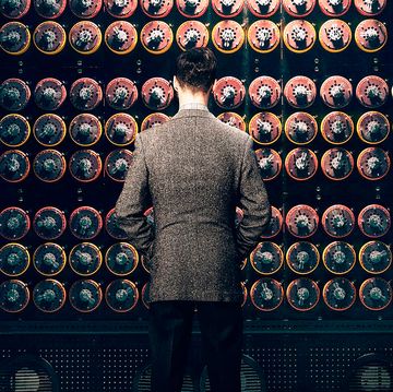 a person standing in front of a wall of colorful machines