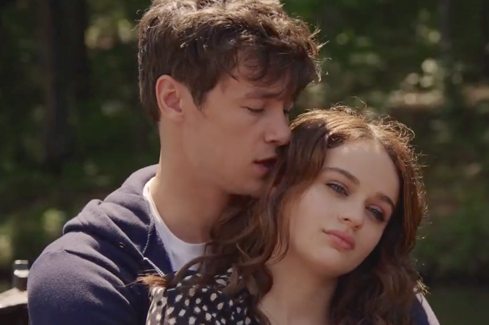 kyle allen as skylar and joey king as tessa sitting in an embrace on a boat in the in between