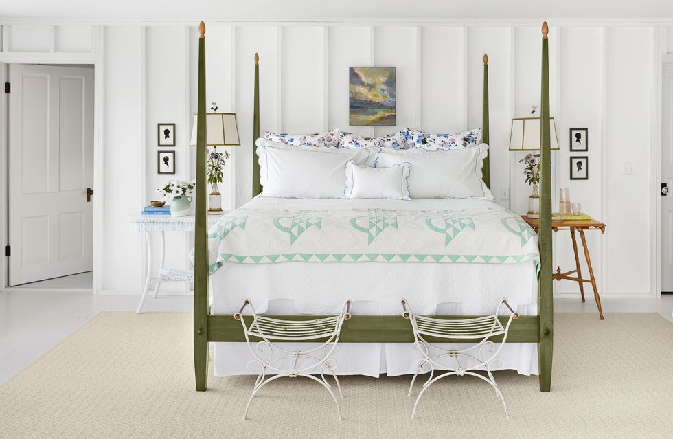 a white bedroom with a green bed