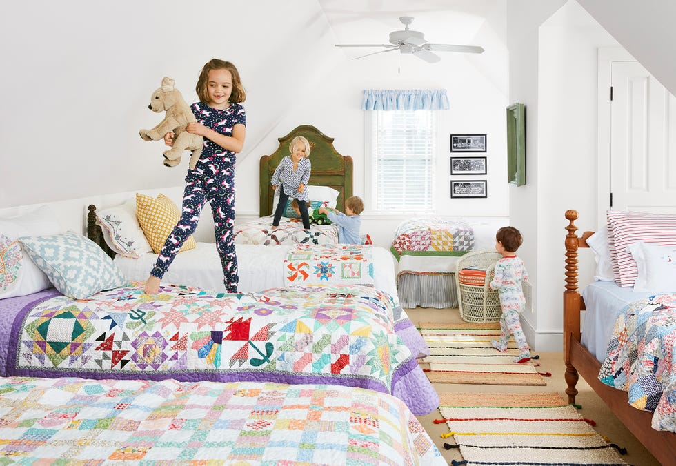 lake house bedroom with lots of beds topped with colorful quilts