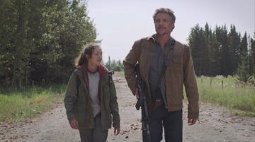 ellie and joel walk down a deserted road in a scene from 'the last of us'