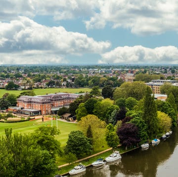 aerial view of a hotel and sports grounds beside a river aerial view of a hotel and sports grounds beside a river