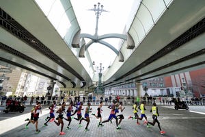 varios atletas de élite corren el maratón de tokio 2020 por debajo de un puente