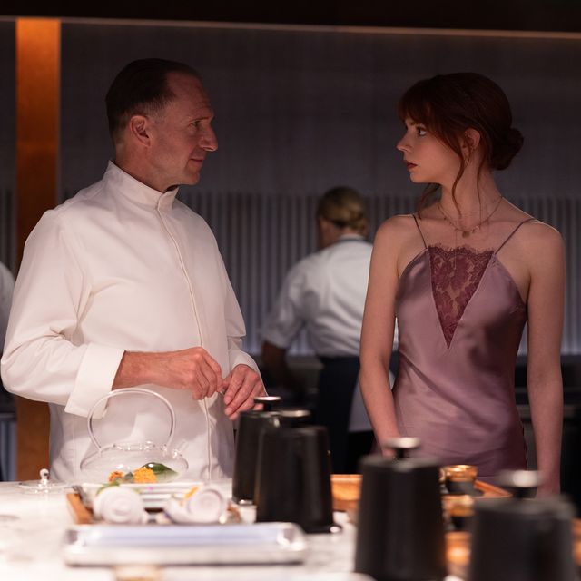 film still from the menu, showing ralph fiennes as chef julian and anya taylor joy as margot looking at each other while standing in the kitchen