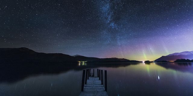The Milky Way and Aurora Borealis from a jetty over Derwent water. English Lake District. UK