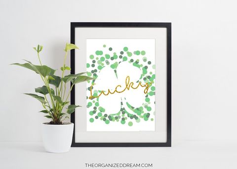 framed printable with a white shamrock outlined by green dots with lucky in gold written across it