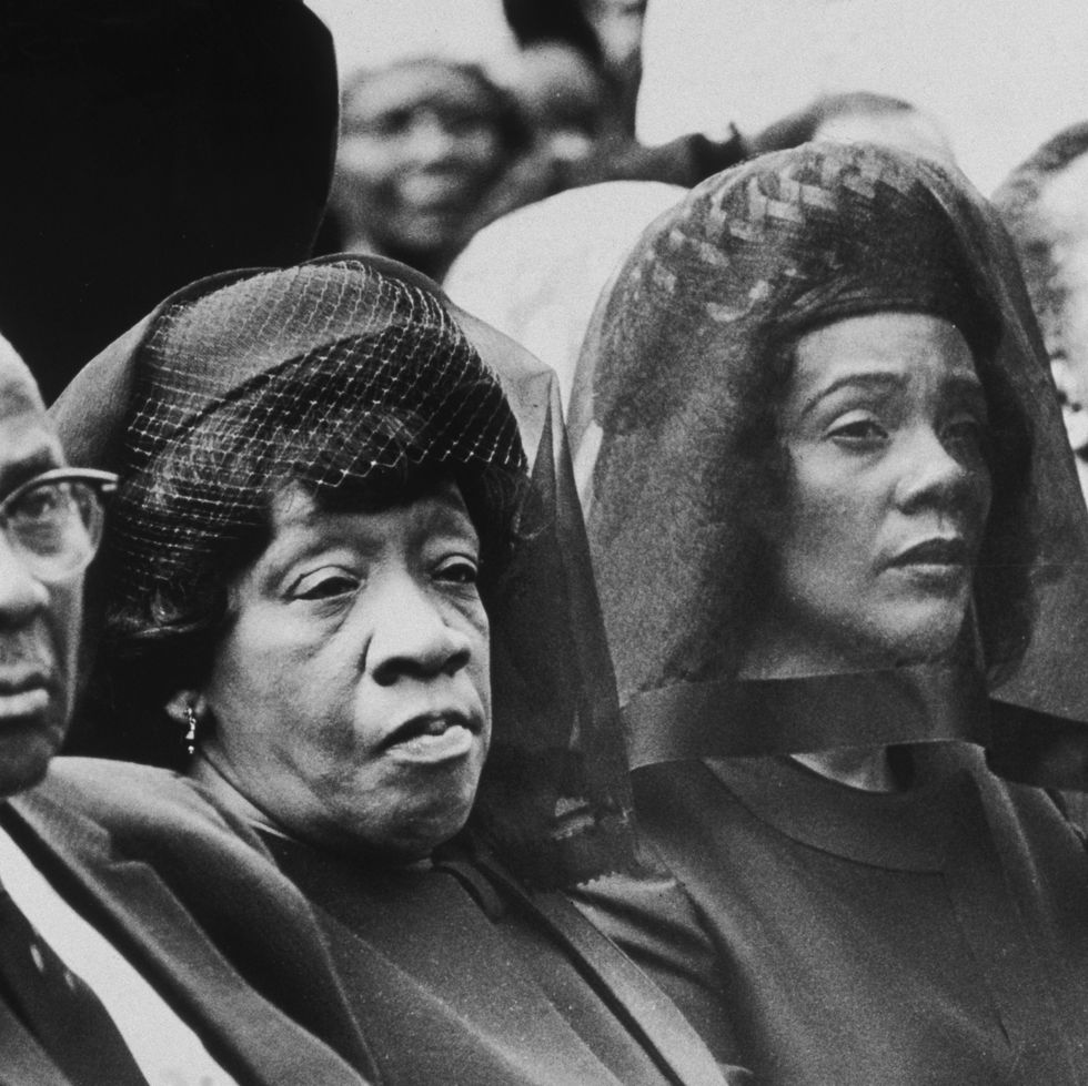 martin luther king sr and alberta king sit and look right, they were formal attire, martin sr wears glasses, alberta wears a hat with netting and a veil