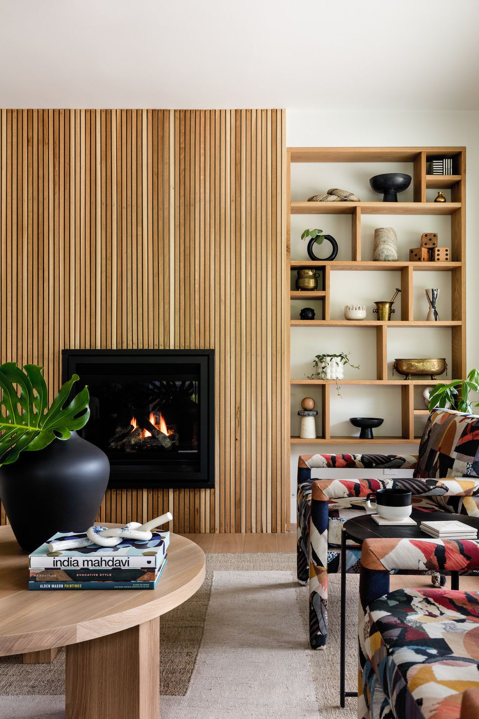 living wood with wood paneled fireplace and patterned armchairs