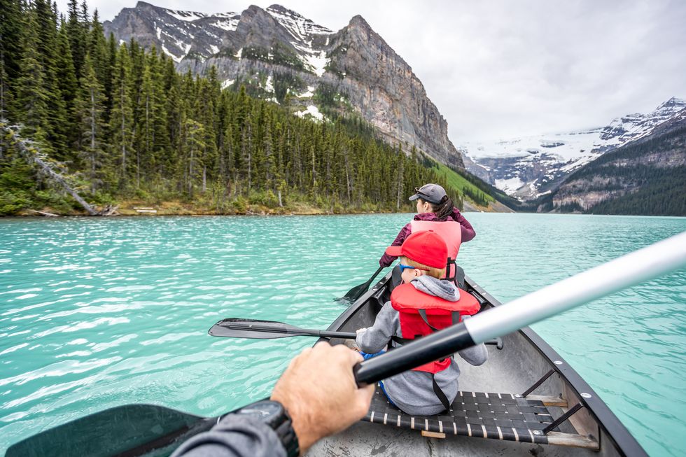 pov family canoeing at lake louise in banff national park in summer, alberta, canada