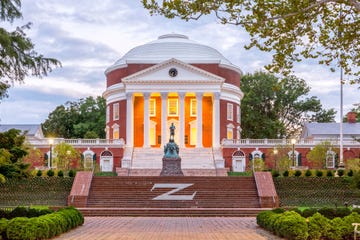 the rotunda at the university of virginia at dusk with thomas jefferson statue in the foreground