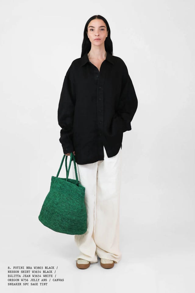 fashionable outfit with a black shirt white pants and a green tote bag