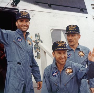 three men dressed in matching outfits wave and smile