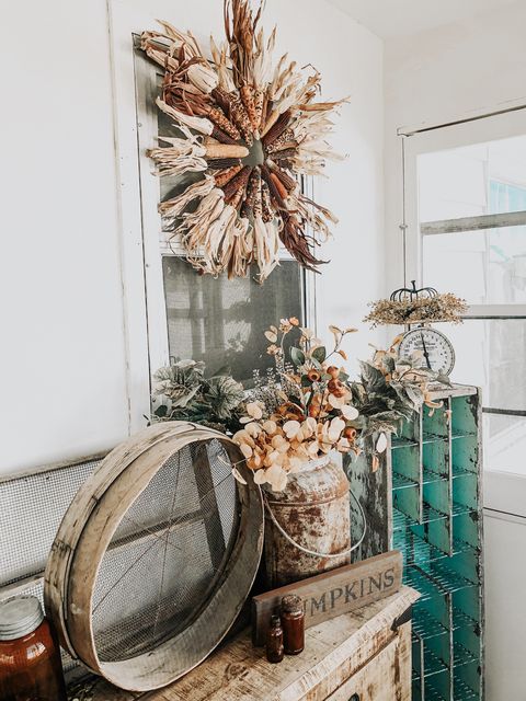 diy cornstalk decor like a wreath made out of indian corn cob on a porch with other items like a pumpkins sign, rusted milk jug with dried vegetation and more