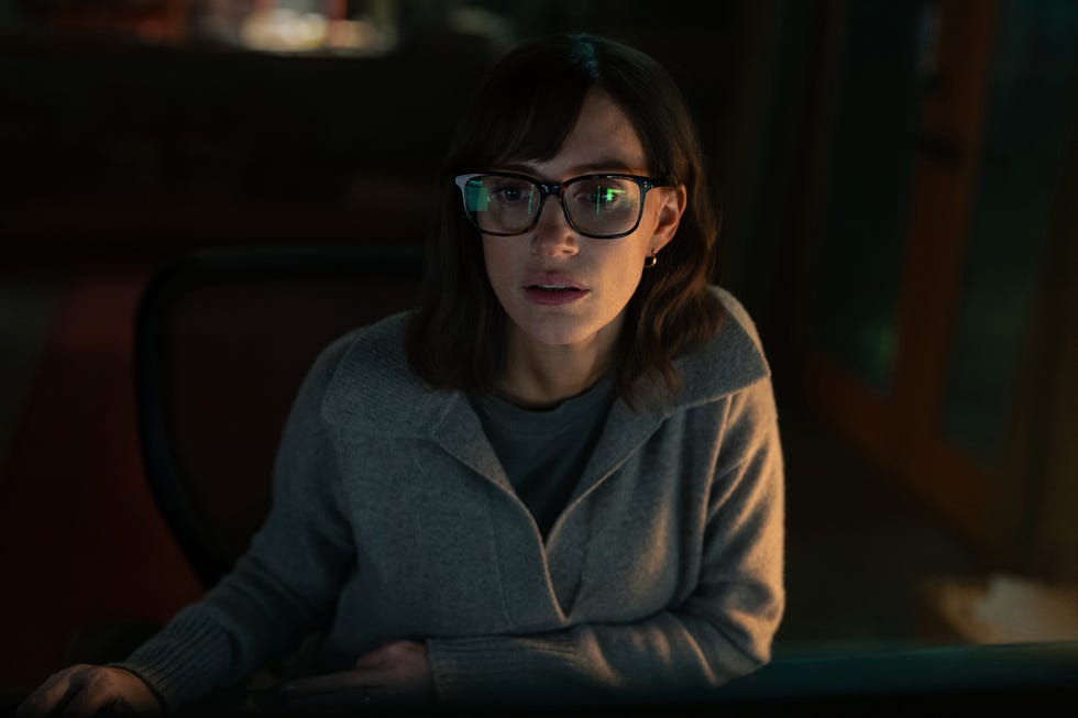 Person sitting at a desk in a dimly lit room