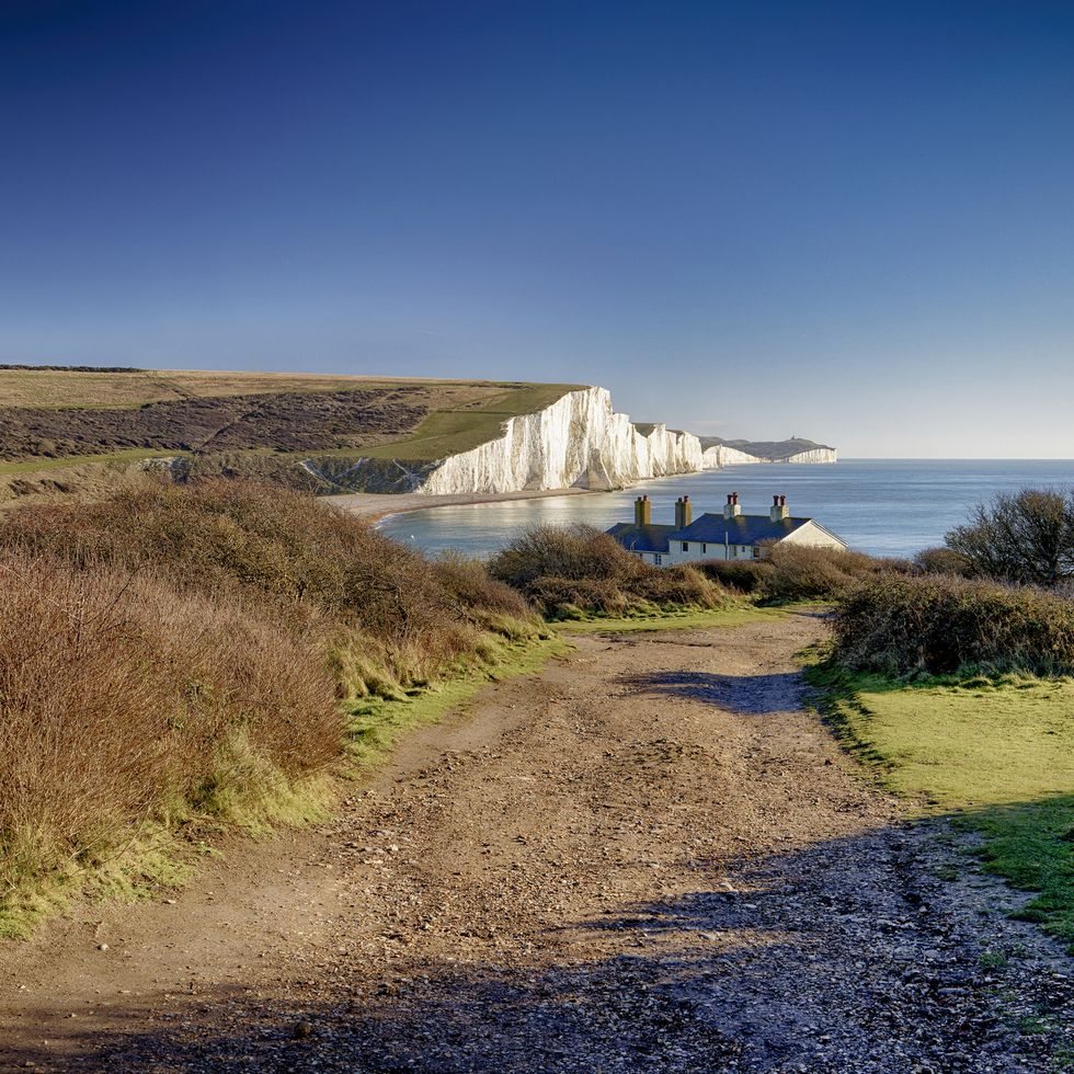 a rough road to coastguard cottages with the view of the seven sisters white cliffs as seen from cuckmere haven sussex uk