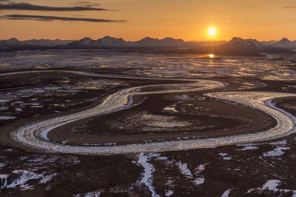 The sun sets behind the Wood River Mountains and Snake River within the Togiak National Wildlife Refuge, Alaska.