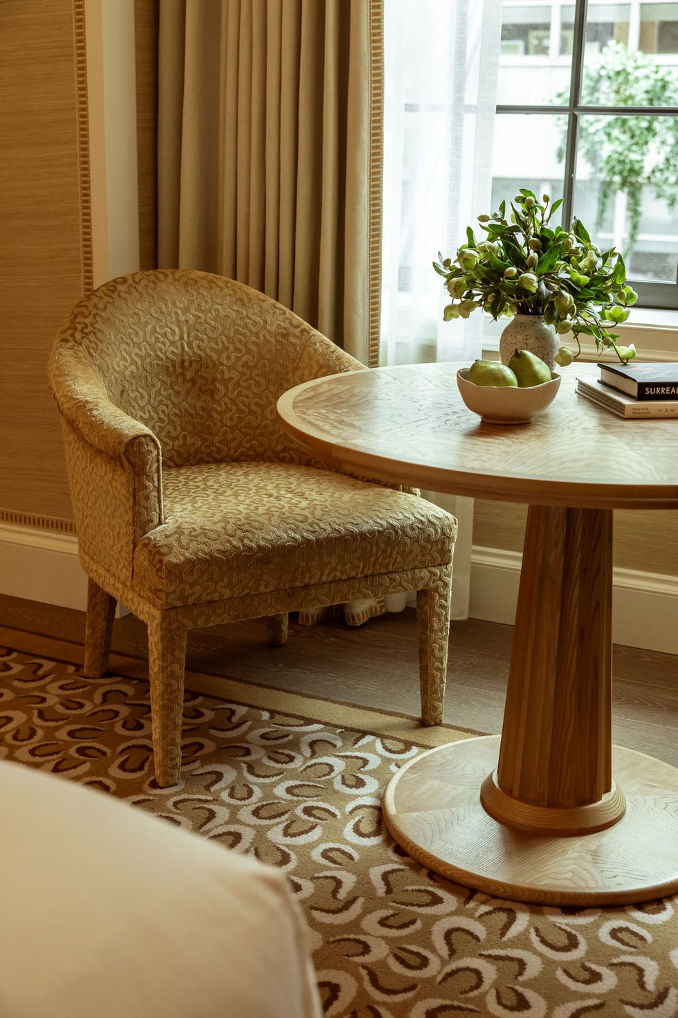 Cozy seating area featuring a patterned chair and a round wooden table