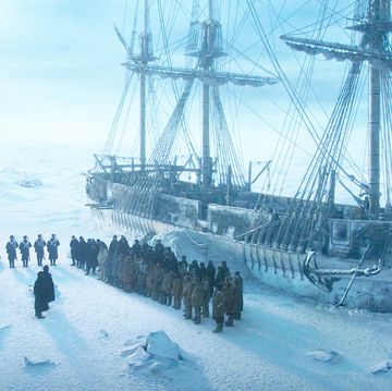 a group of people standing on a ship in the snow