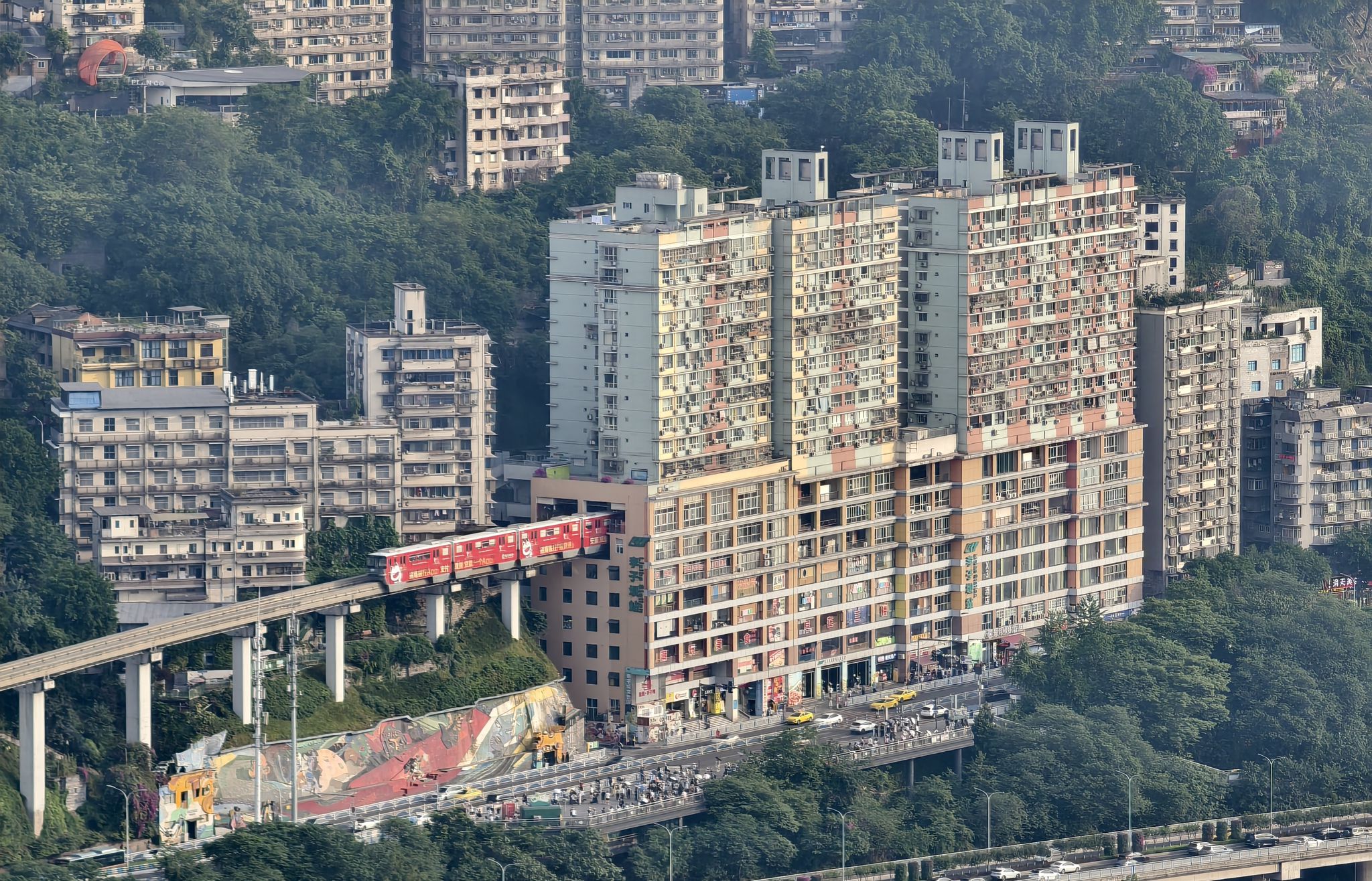 metro rijdt door woongebouw in het district liziba in chongqing