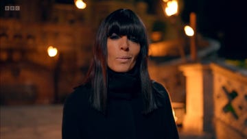 the traitors season 3, claudia winkleman outside the castle at night with full fringe and a black cloak